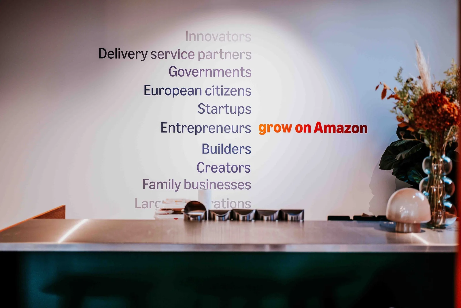 A wall listing the people and businesses Amazon works with, above the bar